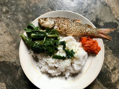 Soslu ızgara balık, pilav ve sebze salatası.