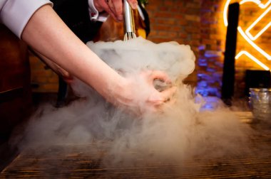 making ice cream with liquid nitrogen female hands holding a bowl in fumes