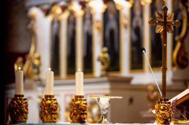 interiors and details in catholic church view of the altar, candles and the chalice