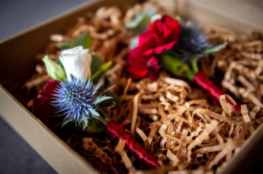 flowers bouquets bouquets and boutonnieres lying in a cardboard box red flower in boutonniere