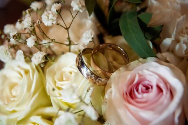 hands, wedding rings and marriage vows wedding rings on a bouquet of flowers