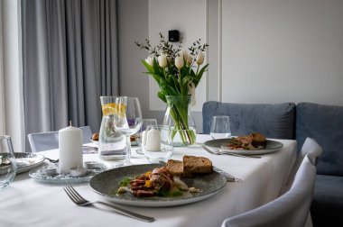 tableware and table decorations at celebrations view from above the table to dining room, bouquets of flowers on the table, party at home