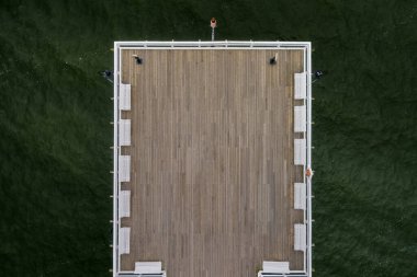 wooden pier on the background of green water, top down view