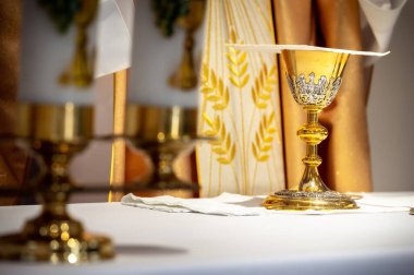interiors and details in catholic church view of the altar, candles, priest and the chalice