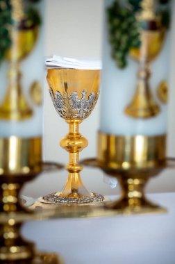 interiors and details in catholic church view of the altar, candles and the chalice