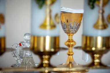 interiors and details in catholic church view of the altar, candles and the chalice