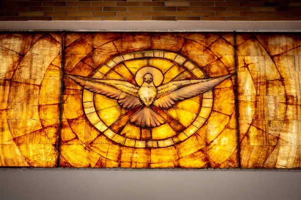 interiors and details in catholic church stained glass window with the holy spirit in the form of a dove