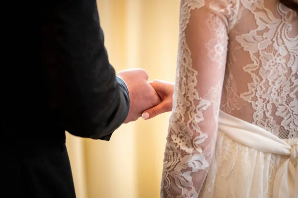 hands, wedding rings and marriage vows intertwined hands of the bride and groom