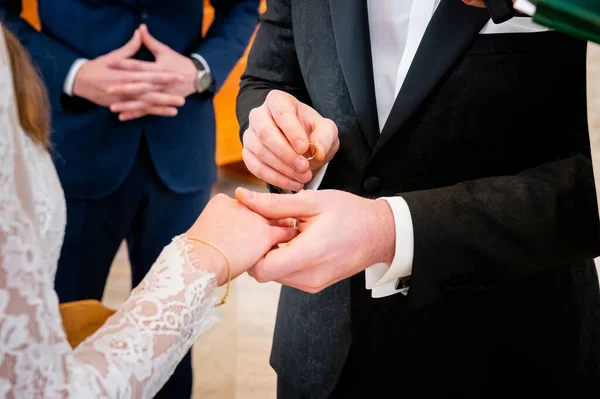 hands, wedding rings and marriage vows the groom holds and puts a wedding ring on the bride's finger