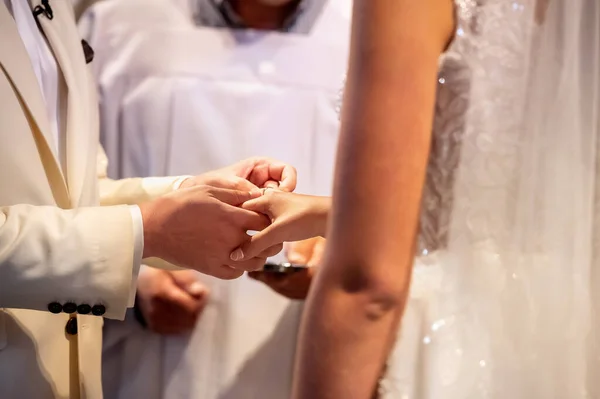 hands, wedding rings and marriage vows the groom holds and puts a wedding ring on the bride's finger