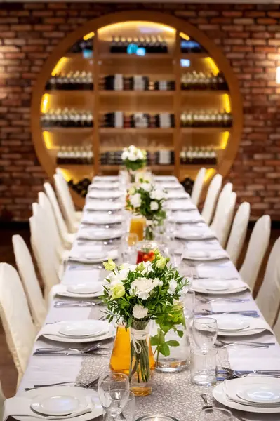 tableware and table decorations at celebrations view from above the table to the banquet hall, bouquets of flowers on the table