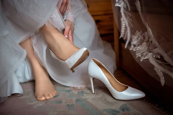 bride and groom's wardrobe and items of clothing hands and feet of the bride wearing stiletto shoes