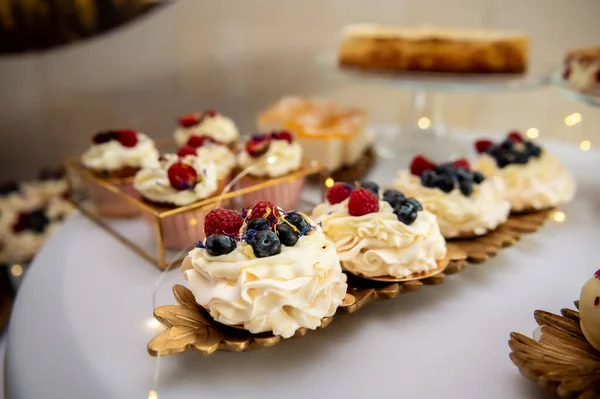 sweets, cake and cookies meringue with raspberries and blueberries