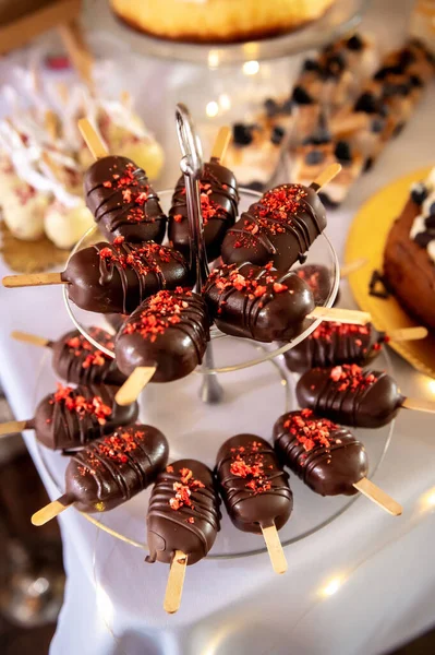 sweets, cake and cookies sweet on a stick in chocolate with sprinkles