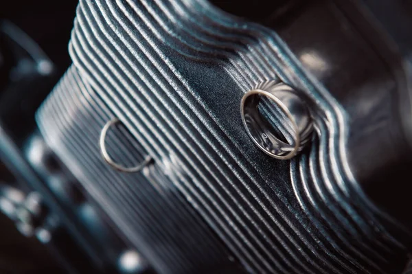 hands, wedding rings and marriage vows white gold wedding rings lying on a motorcycle engine