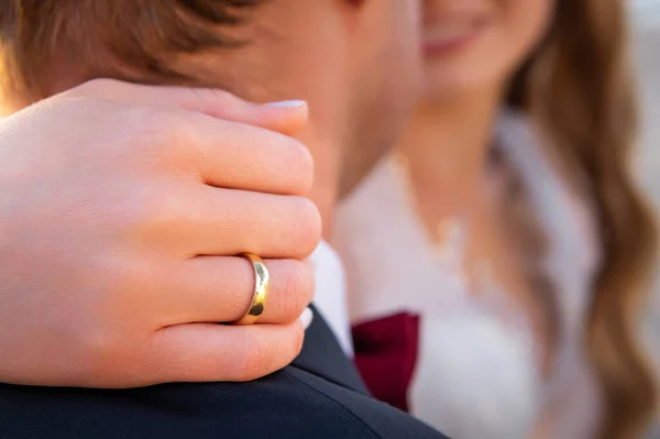 hands, wedding rings and marriage vows the bride holds her hand on the groom's neck
