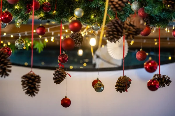 winter christmas decorations, pine cones, ribbon baubles and lights hanging from the ceiling