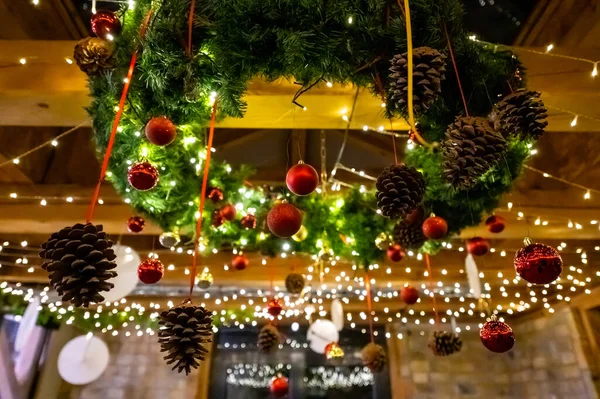 winter christmas decorations, pine cones, ribbon baubles and lights hanging from the ceiling