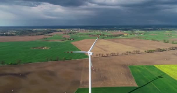 Strzał Drona Działającej Turbiny Wiatrowej Tle Pól Wiosennych Kwitnącej Rzeczki — Wideo stockowe