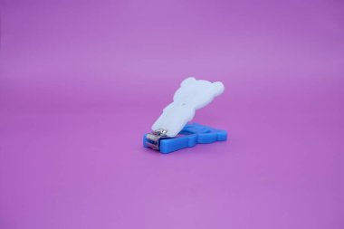 Güzel tırnak makasları mor arka planda izole edilmiş. Mavi ve beyaz kombinasyonlu şirin tırnak makasları