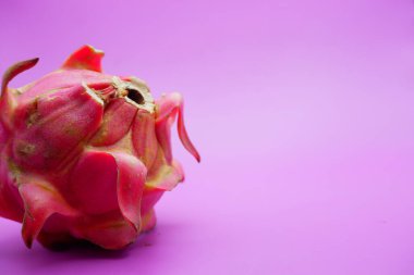 Mor arka planda izole edilmiş bir ejderha meyvesi