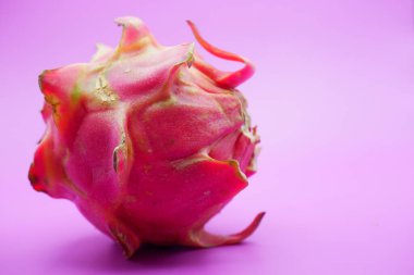 Mor arka planda izole edilmiş bir ejderha meyvesi