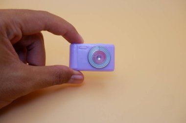 Tarafsız Arkaplanda Parmaklar Arasında Sıkıştırılmış Kamera