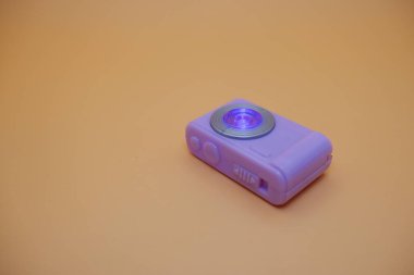 Bej Arkaplanda Parlak Mercekli Mor Oyuncak Kamerası