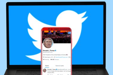 Mobil ekranda twitter uygulaması koz profili ve bilgisayar ekranında bulanık twitter web sitesi logosu