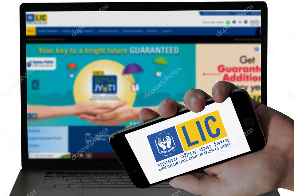 LIC Bank logo in mobile screen and their blurred website displayed in Laptop screen. editorial image.