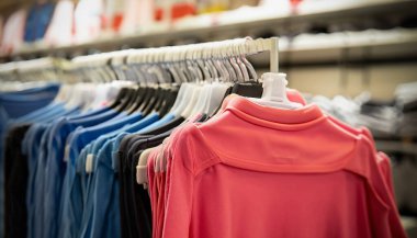 Bir sürü düz tişört. Bulanık giyim mağazası geçmişi. seçici odak.