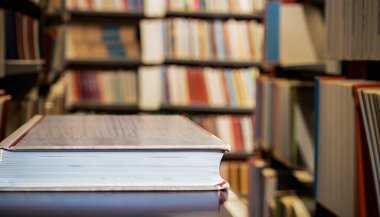 Bir kitap önde ve arka planda bir sürü bulanık kitap var. seçici odak resmi