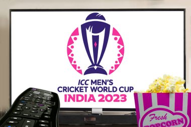 ICC erkekler kriket dünya kupası 2023 logosu önünde patlamış mısırla televizyon yayınladı. Kriket konsepti ile eğlence.