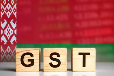 GST displayed on wooden letter blocks with Belarus flag background. tax concept. illustration design.