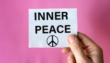 İç huzur, hafif pembe arka planda izole edilmiş, el ele tutuşma kağıdında sergileniyor..