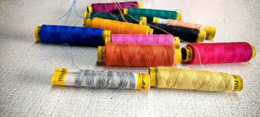 Beyaz masa arkaplanındaki farklı renk iplikleri. seçici odak. 