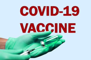COVID 19 aşı metni. Önde şırınga enjeksiyonu ve ilaç posteri var..