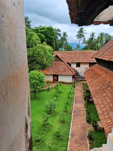 stock image  A panoramic view of a traditional Kerala style tiled roof in Padmanabhapuram Palace, surrounded by lush greenery and a serene landscape.