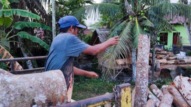 Aceh, Endonezya 26 Mart 2023: Asyalı çalışkan adamlar nakliye kamyonlarından kirişleri indiriyor. Kuzey Aceh, Aceh Eyaleti, Endonezya 26 Mart 2023
