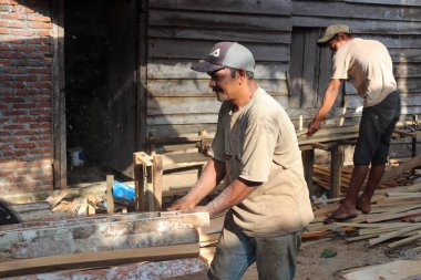 Aceh, Endonezya 28 Mart 2023: çalışkan Asyalı adamlar bir kereste fabrikasında çalışıyor, bir köy bölgesinde kereste fabrikasında. Kuzey Aceh, Aceh Eyaleti, Endonezya 28 Mart 2023