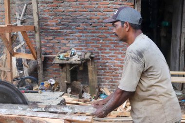 Aceh, Endonezya 28 Mart 2023: çalışkan Asyalı adamlar bir kereste fabrikasında çalışıyor, bir köy bölgesinde kereste fabrikasında. Kuzey Aceh, Aceh Eyaleti, Endonezya 28 Mart 2023