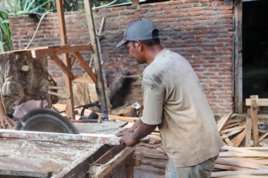 Aceh, Endonezya 28 Mart 2023: çalışkan Asyalı adamlar bir kereste fabrikasında çalışıyor, bir köy bölgesinde kereste fabrikasında. Kuzey Aceh, Aceh Eyaleti, Endonezya 28 Mart 2023