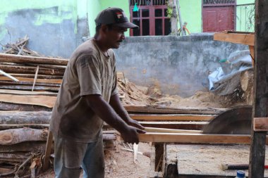 Aceh, Endonezya 28 Mart 2023: çalışkan Asyalı adamlar bir kereste fabrikasında çalışıyor, bir köy bölgesinde kereste fabrikasında. Kuzey Aceh, Aceh Eyaleti, Endonezya 28 Mart 2023