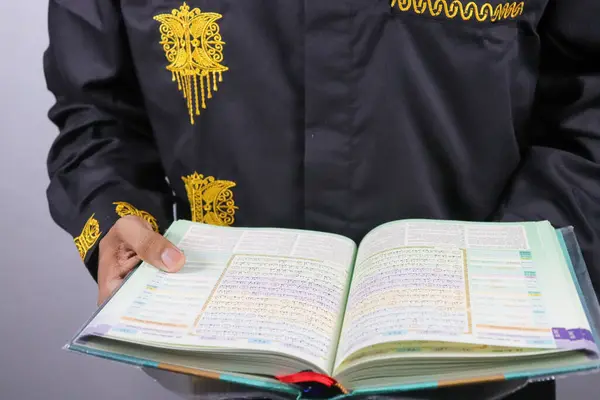 Müslüman adam Kuran ve Kuran ile namaz kılıyor.