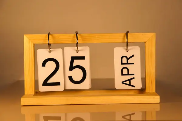 25 Nisan 'da. Takvim ahşap çerçeve beyaz çerçeve bahar günü arka planı. Yaz ayı kış günü konsepti.