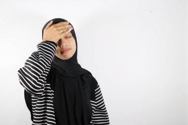 Genç müslüman kız tesettürlü, eli gözlerle kaplı, dur hareketi gösteriyor, kameraya bakıyor..