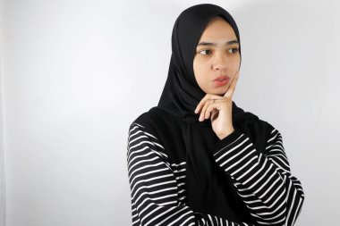 Müslüman kadın tesettürlü ve kameraya bakıyor, beyaz üzerine izole edilmiş.