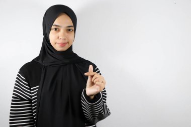Beyaz arka planda izole edilmiş fotokopi alanına el hareketi yapan Asyalı Müslüman kadın.