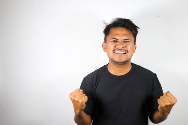 Asyalı genç adam mutlu bir ifadeyle parmaklarını gösteriyor. beyaz arkaplanda izole.