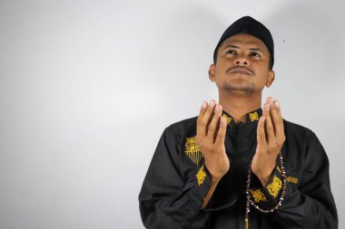 Müslüman Asyalı bir adam Kuran tutuyor.